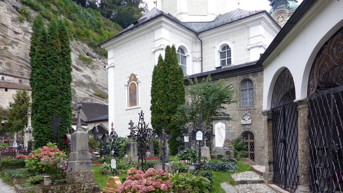 Arkadengänge und schmiedeeiserne Grabkreuze auf dem Petersfriedhof Salzburg vor der Stiftskirche